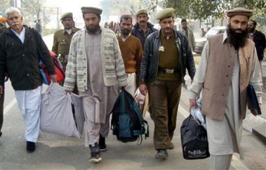 Pakistani prisoners are escorted by Indian policemen before they cross over to their country at the India and Pakistan joint border check post in Wagah, India Monday, Dec. 26, 2005.