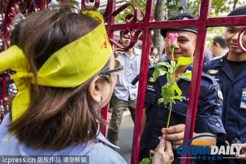 英拉稱不會武力驅(qū)散示威 警民和諧相處互贈花朵