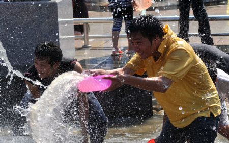 Young people spray water to each other during Double Seventh Festival