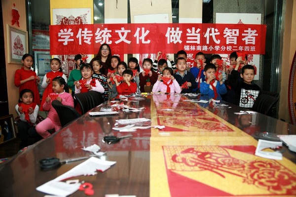 Young pupils learn paper cutting