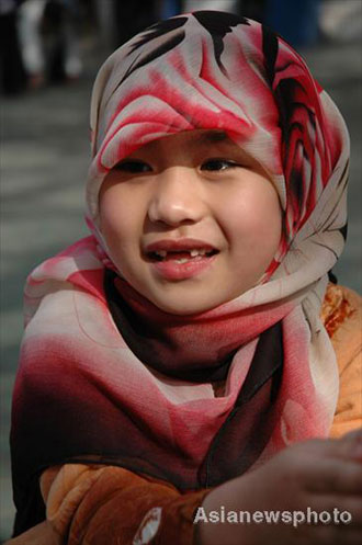 Maxu chaoyang, a girl of the Hui ethnic group, smiles as she plays with other pupils at Lanzhou Qing Hua Primary School, in Lanzhou, capital of Northwest China's Gansu Province, March 15, 2008. The Beijing Organizing Committee for the Olympic Games (BOCOG) recently invited the school, which is known for having students from many ethnic groups, to submit photographs of smiling children for possible use in the August 8 Opening Ceremony of the Beijing Olympic Games. BOCOG started collecting photographs of children's smiling faces from around the world on Sept 4 last year. [Asianewsphoto]