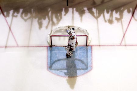 Carolina Hurricanes' goaltender Cam Ward looks on as shadows of Edmonton Oilers fans celebrating along the boards are cast on the ice after Oilers' Ryan Smyth scored during the third period of Game 6 in their NHL Stanley Cup ice hockey finals in Edmonton, Alberta, June 17, 2006. 