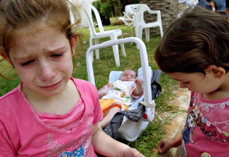 A young Lebanese refugee from southern Lebanon cries near her sisters before leaving a hotel in Tyres (Soure) port to be evacuated to Cyprus in a boat rented by Germany July 24, 2006.