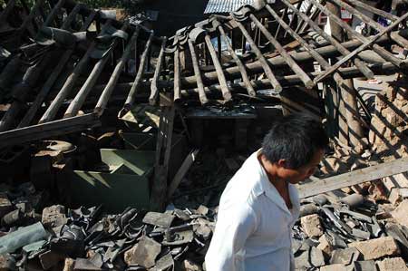 A local resident walks past the debris of houses following a strong earthquake in Ning'er, Southwest China's Yunnan Province, June 3, 2007. The 6.4-magnitude quake struck the county seat of Ning'er shortly after 5:30 a.m. (2130 GMT Saturday), bringing down houses and killing at least three people, one a 4-year-old, and injuring 300, Xinhua reported. [Life News]