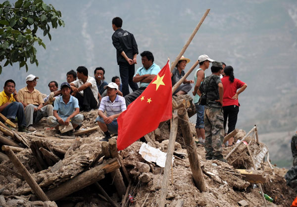 Landslide survivors waiting for families on ruins