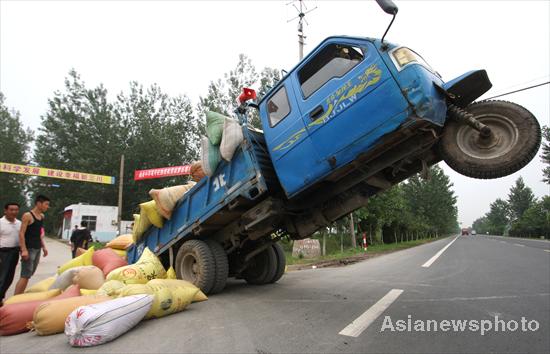 Overloaded farm vehicle does a wheelie