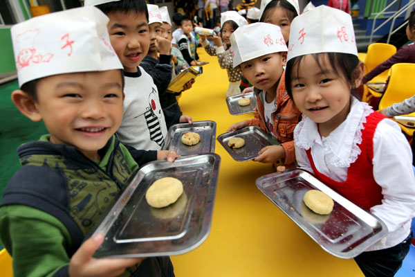 Children learn to make festival delicacy