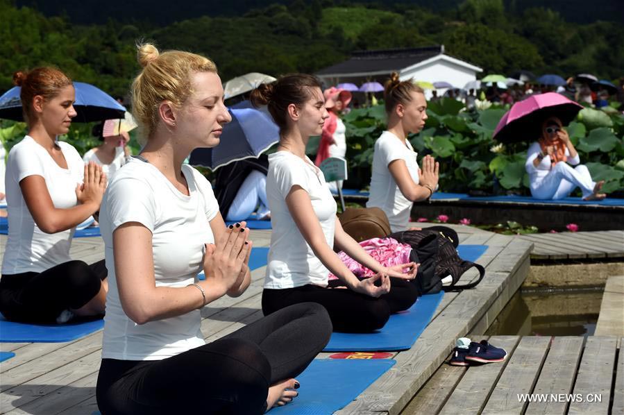 Fans practice yoga at lotus culture park in SE China's Fujian