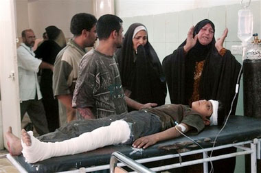 A mother cries over her young boy wounded in crossfire during street fights, Sunday, July 9, 2006, in the Jihad area of western Baghdad, Iraq. Gunmen stopped cars in western Baghdad, grabbing people from the street and separating Sunni Arabs from the rest, killing at least 37 people, police said, in a dramatic escalation of sectarian violence in the country. The attack in the dangerous Jihad neighborhood was apparently in retaliation for the car bombing the night before of a local Shiite mosque. (AP