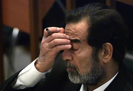 Ousted Iraqi leader Saddam Hussein listens to witness testimony during his trial in Baghdad's heavily fortified Green Zone October 17, 2006. 