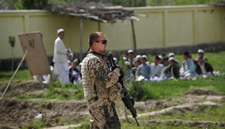 Afghan school continues as soldiers guard aside