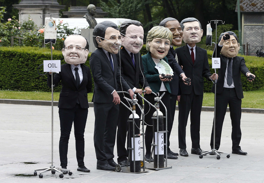 Oxfam demonstrators wearing masks of G7 leaders protest in Brussels